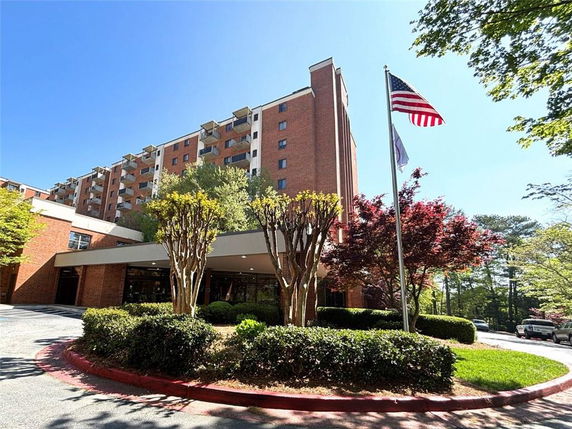 Front view of a multi-story brick building with balconies.