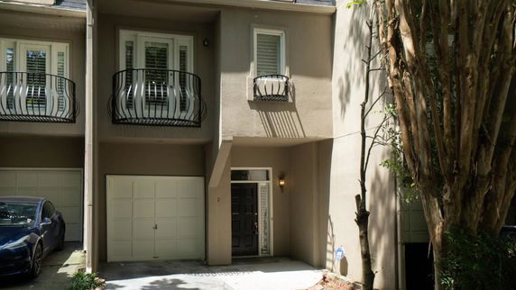 Front view of a multi-story house with balconies and a garage.