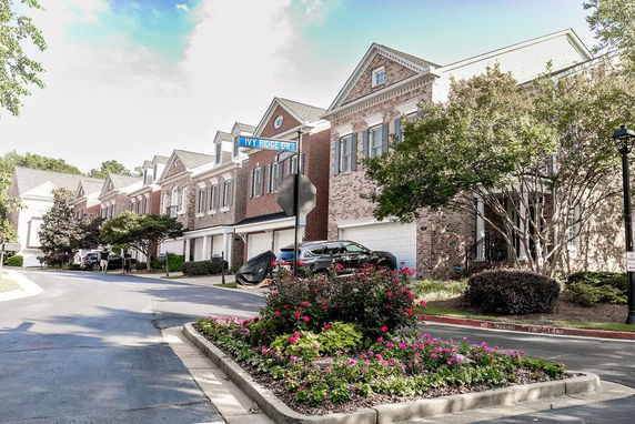 Front view of a row of two-story brick townhouses with garages.