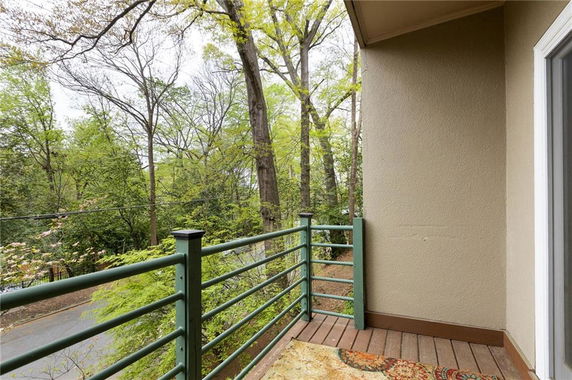 View from a balcony overlooking trees and a road