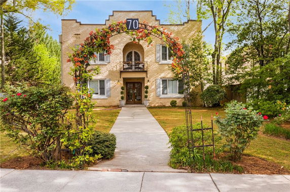 Front view of a two-story house with an archway and balcony.