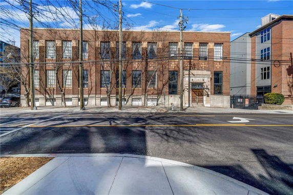 Front view of a two-story brick building with large windows.