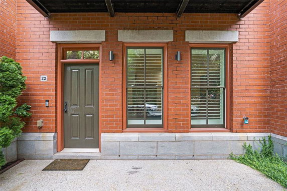 Front view of a brick building with a doorway and two windows.