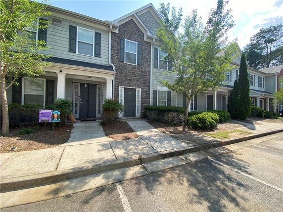 Front view of a two-story townhouse with stone and siding facade.