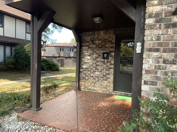 Front entrance of a house with brick exterior and covered porch.