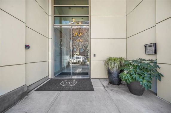 Entrance of a building with glass doors and potted plants.