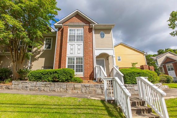 Front view of a two-story house with brick and siding exterior.