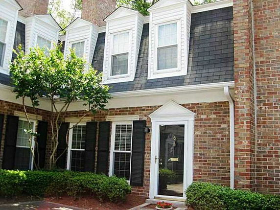 Front view of a two-story house with brick exterior and dormer windows.