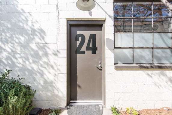 Front view of a building entrance with a numbered door and a window.