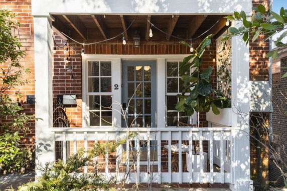Front view of a house with a small porch and brick exterior.