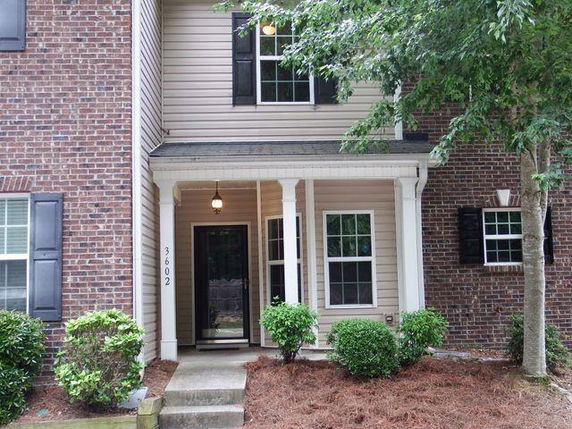 Front view of a house with a brick façade and covered entrance.
