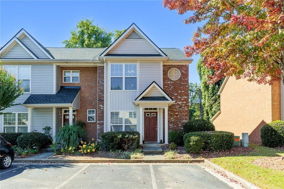 Front view of a two-story townhouse with a combination of brick and siding exterior.