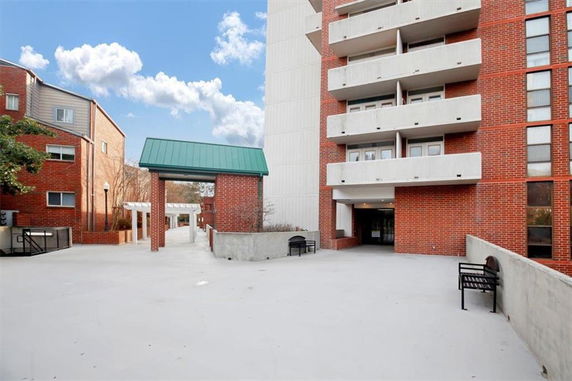 Front view of a multi-story brick building with balconies.