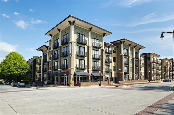 Front view of a multi-story apartment building with balconies.