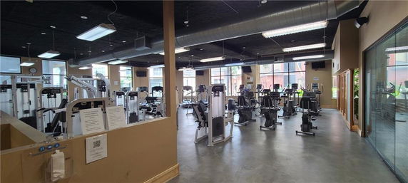 An indoor gym area with various exercise machines and equipment.