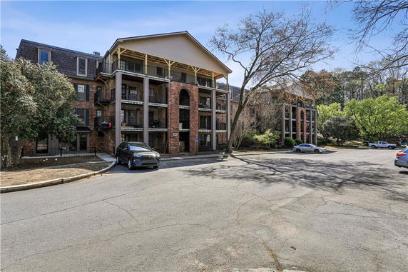 Front view of a multi-story brick apartment building with balconies.