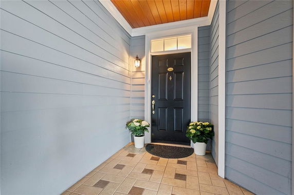 Front view of a house entrance with a black door and blue siding.