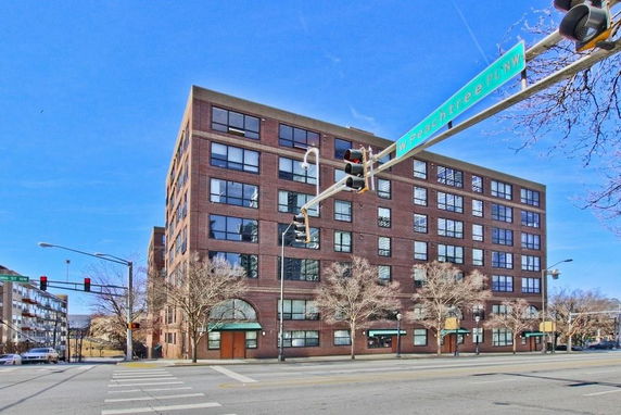 Front view of a multi-story brick building at a street intersection.