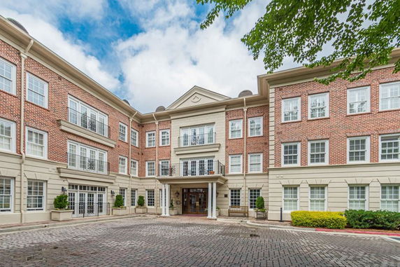 Front view of a three-story brick building with a courtyard entrance.