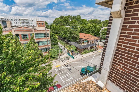 Panoramic view from a building overlooking a street with nearby buildings and trees.
