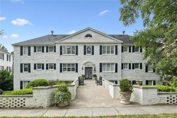 Front view of a large two-story building with a symmetrical design and brick facade.
