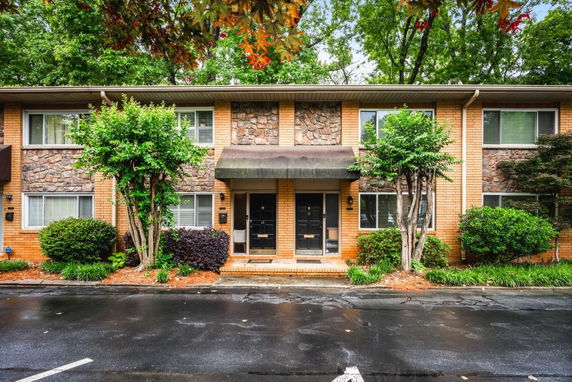 Front view of a two-story residential building with brick and stone facade.