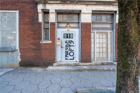 Front view of a brick building with a metal door labeled 'Fairside Lofts'.