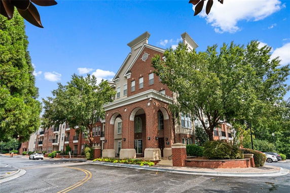 Front view of a multi-story brick building with arched entryway.