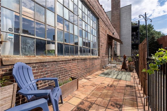Outdoor view of a building exterior with large industrial-style windows and brick walls.