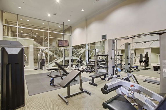 Indoor gym with various fitness equipment and large mirrors.