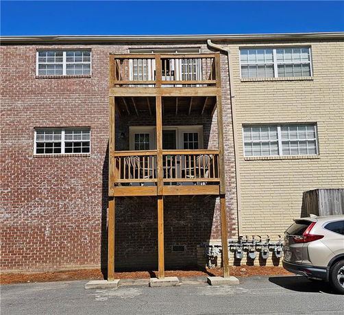 Rear view of a multi-story brick building with wooden balconies.
