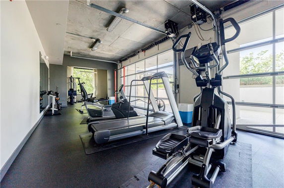 Interior view of a gym with exercise equipment including treadmills and an elliptical machine.