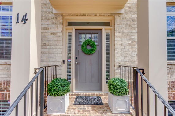 Front view of a house with a gray door and brick exterior.