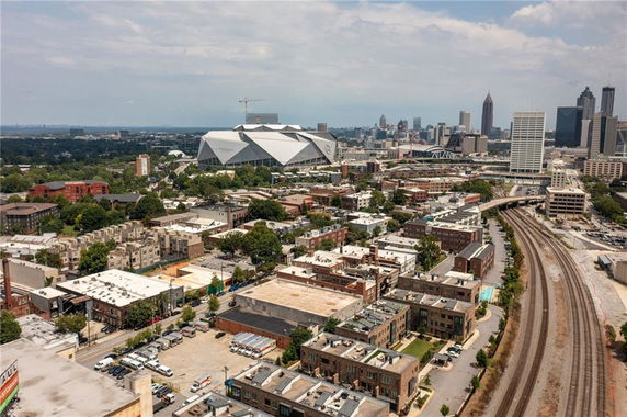 Panoramic view of a cityscape with a stadium and railway tracks.