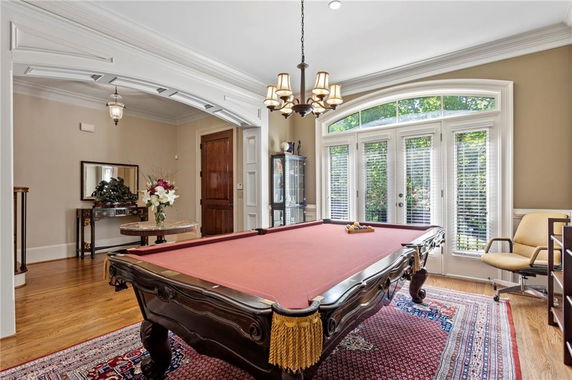 Room with a pool table and large windows.