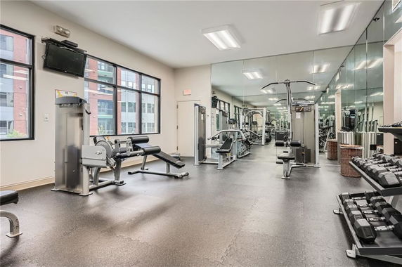 Indoor gym area with exercise equipment and large mirrors.