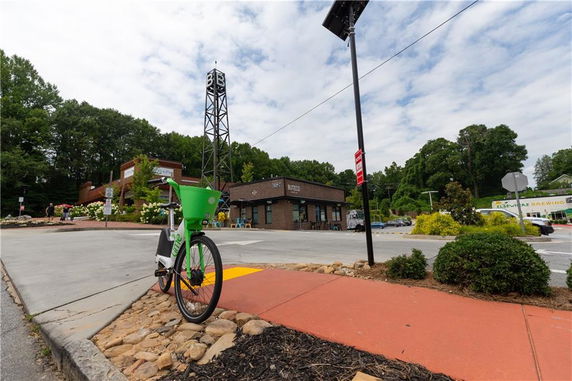 View of a commercial building with a bicycle and parking area in the foreground.