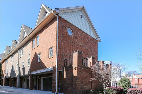 Side view of a multi-story brick townhome with multiple garages.