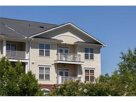 Front view of a two-story house with balconies and pitched roof.