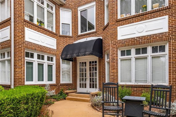 Front view of a brick building entryway with a black awning.