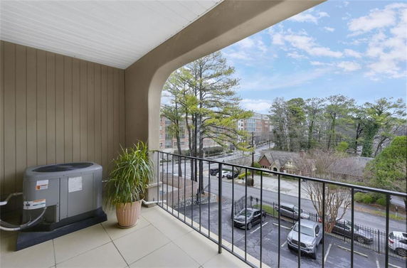 View of surrounding area from a balcony with an air conditioning unit and potted plant.
