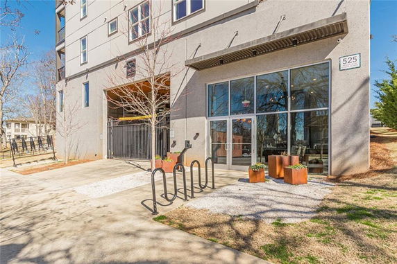 Front view of a building entrance with large glass doors and bike racks.