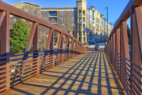 Front view of a multi-story residential building with a walkway bridge leading to it.