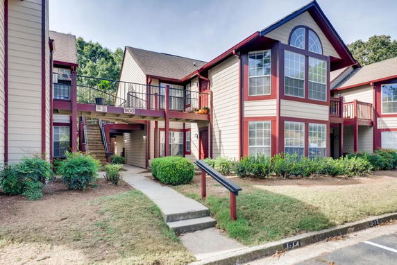 Front view of a two-story apartment complex with brown and red accents.