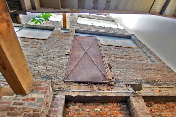 Front view of a brick building with a metal door.