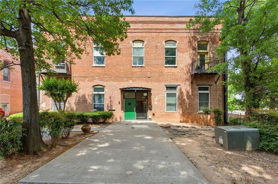 Front view of a two-story brick building with multiple windows and a green door.