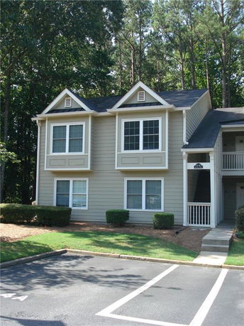 Front view of a two-story house with multiple gables and a covered entrance.