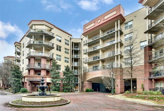 Front view of a multi-story residential building with balconies and an entrance.