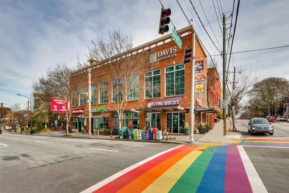 Front view of a two-story brick building with retail shops on the ground floor.