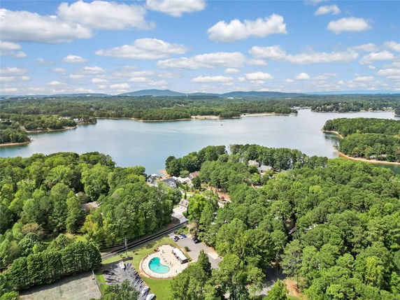 Panoramic view of a lush landscape with a lake and surrounding wooded areas.